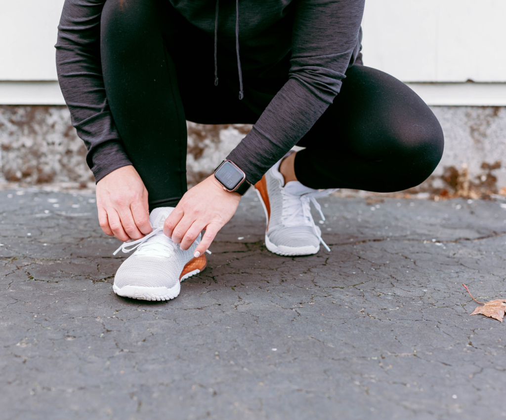 woman tying shoes on the ground