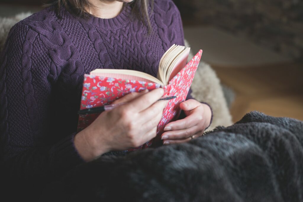 woman in purple sweater with journal