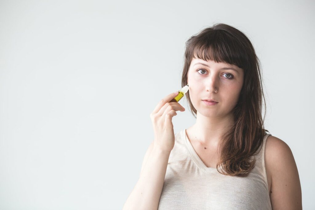 woman rolling essential oils on her skin