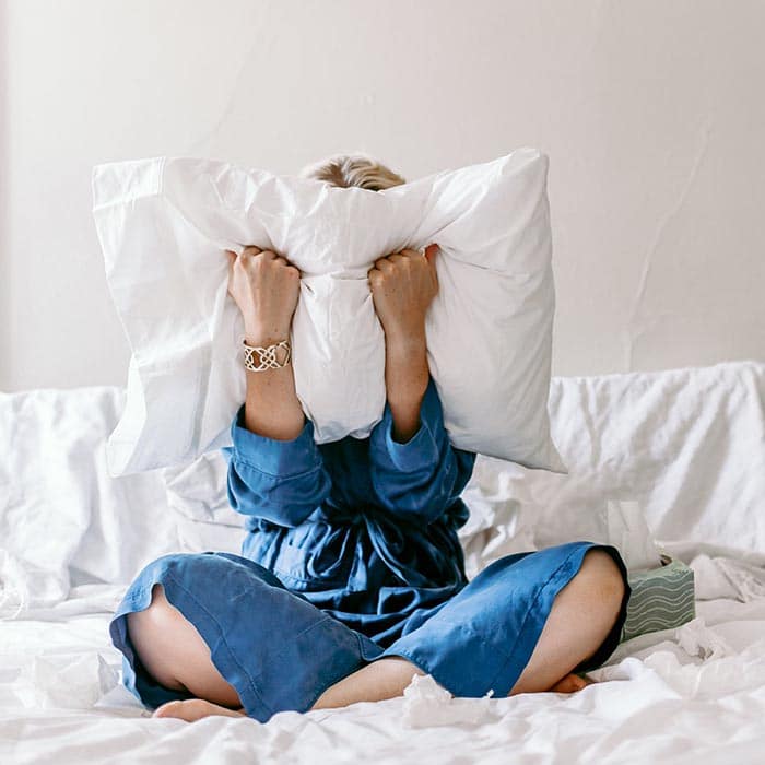 woman screaming into a pillow