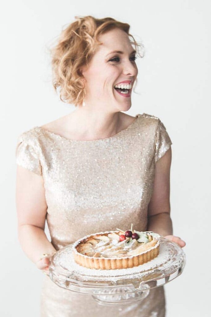 woman laughing holding a cake