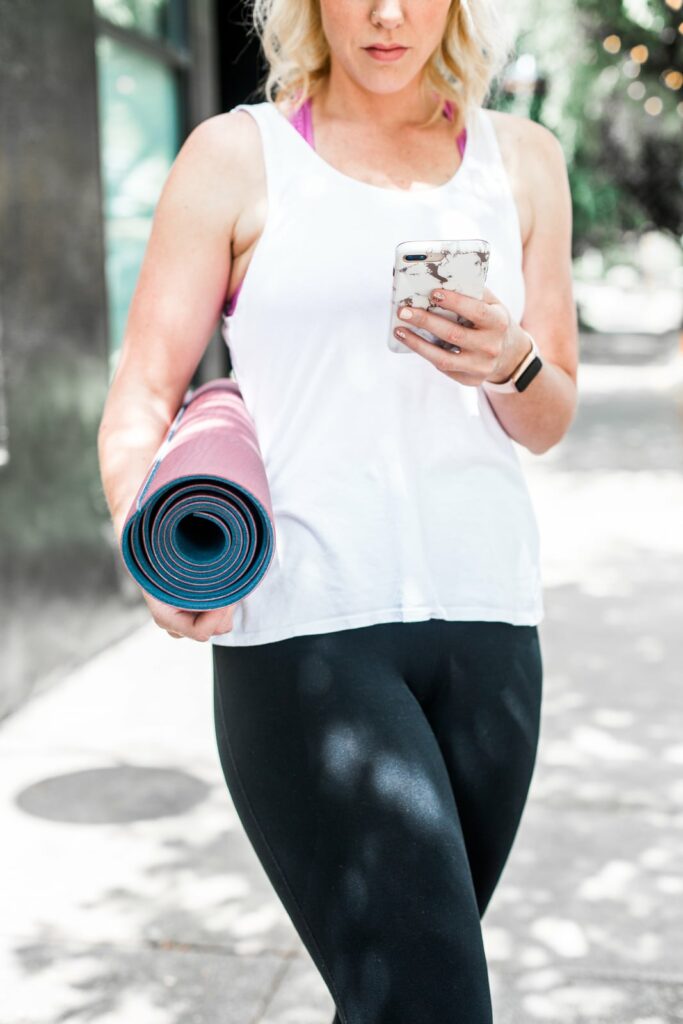 girl with yoga mat and cell phone