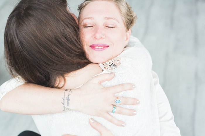 Women in recovery embracing each other