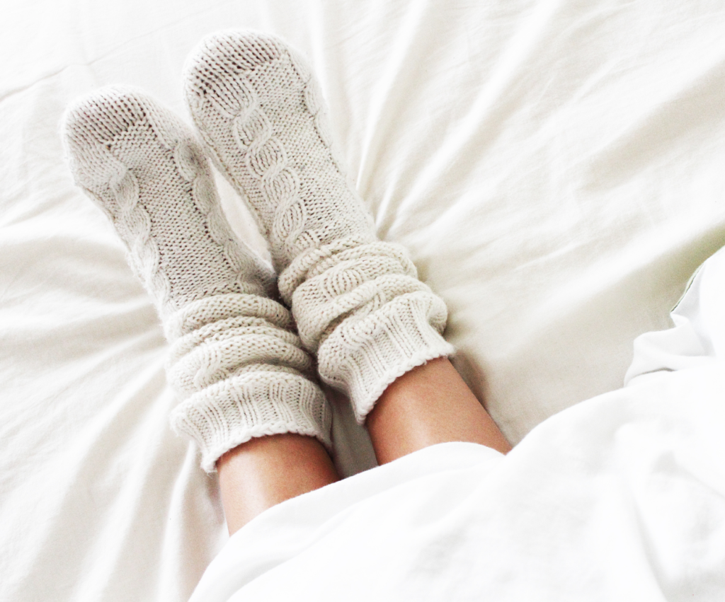 woman wearing cozy socks in bed